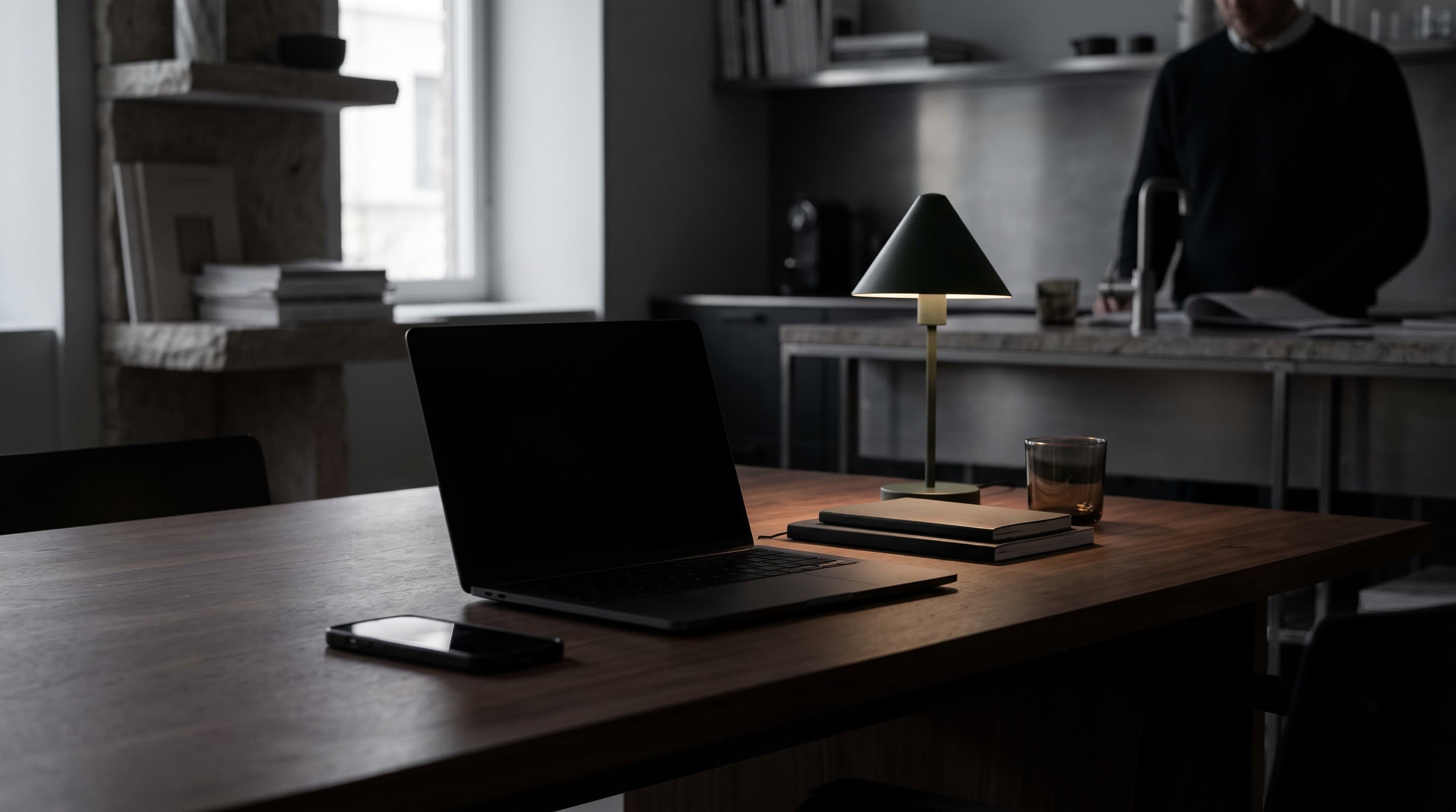 Laptop tertutup dan ponsel di meja yang tenang